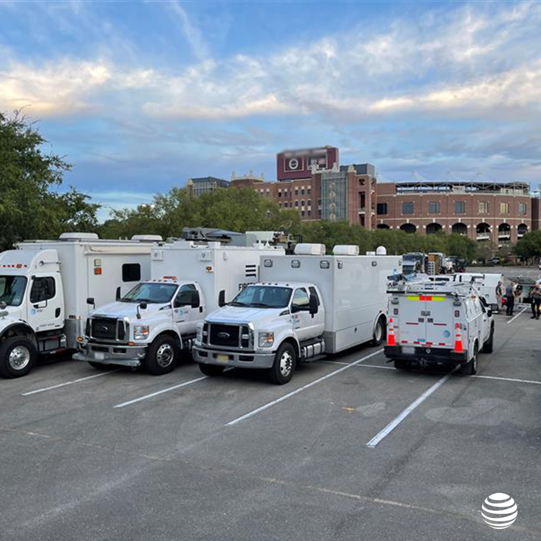 FirstNet SatCOLT  (Satellite Cell on Light Truck) and disaster recovery vehicles in front of college football stadium.