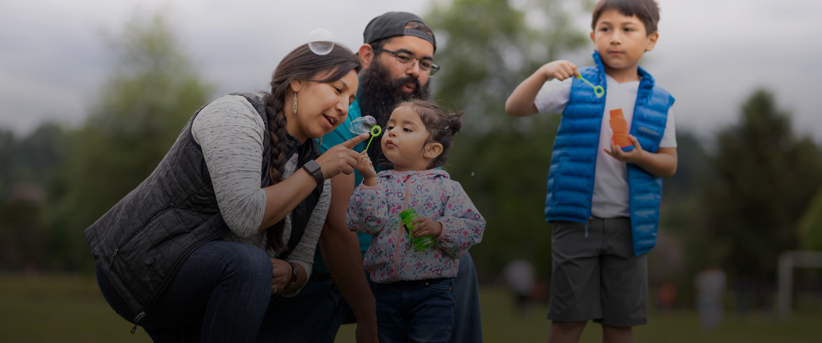 Native American community: a family enjoys the day outdoors, blowing bubbles.