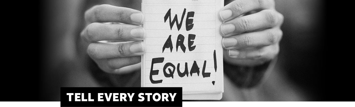 Hands holding notepad that says We are Equal. Tell Every Story