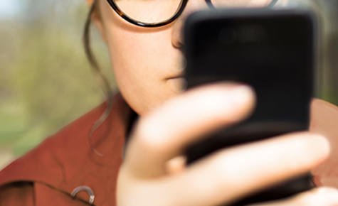 Woman wearing glasses using a cell phone