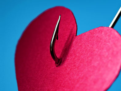 A red paper heart with a fishing hook through it