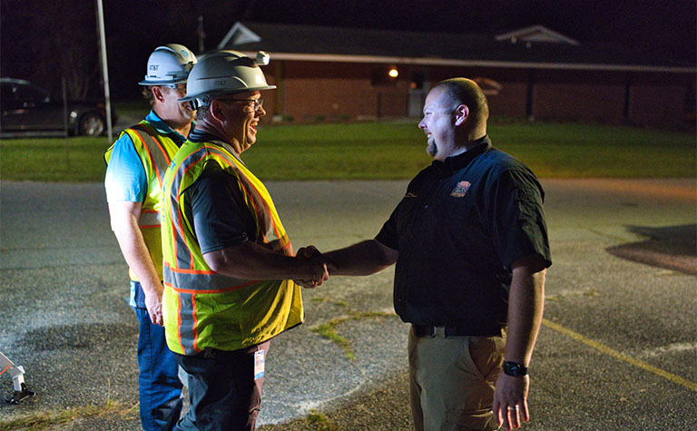 AT&T disaster response team members speak with the Chief of Houston County Fire Department after setting up FirstNet Compact Rapid Deployable (CRD) in Wheeler County, GA