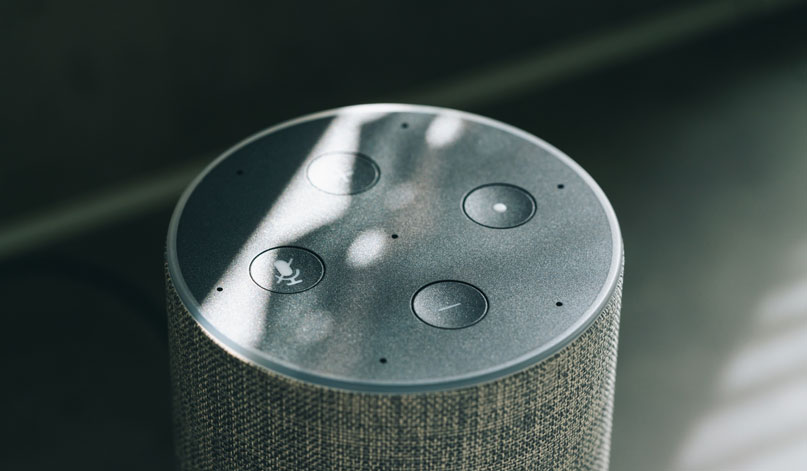 The top of an Alexa speaker with four buttons: stop, start, volume up and volume down.