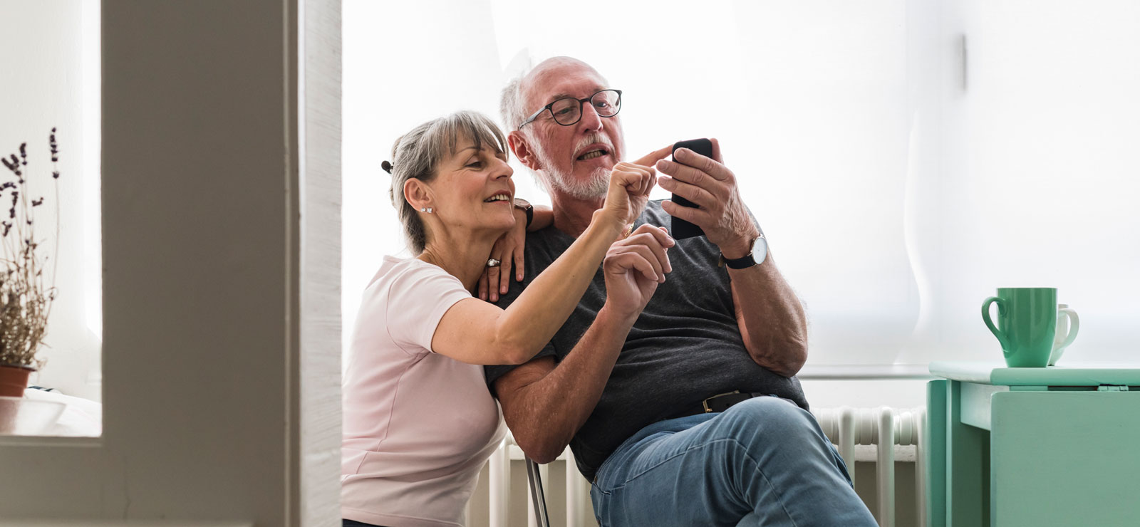 Two people look at a smartphone screen together.