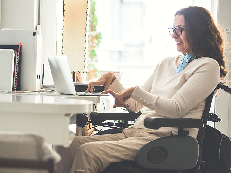Woman in wheelchair using laptop