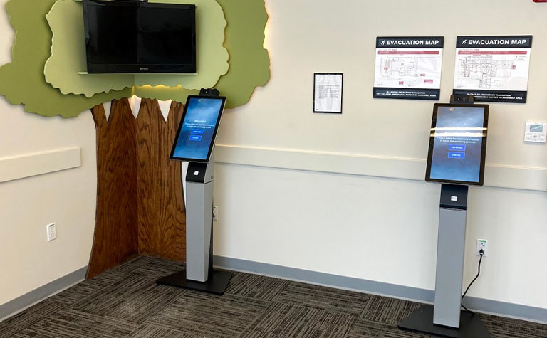 Two temperature screening kiosks using AT&T technology in a waiting area 
