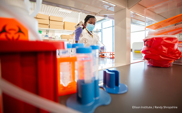 Female researcher at Ellison Institute handles lab equipment. 