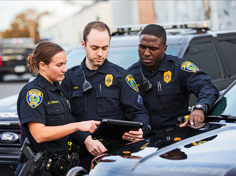Three police officers look at tablet