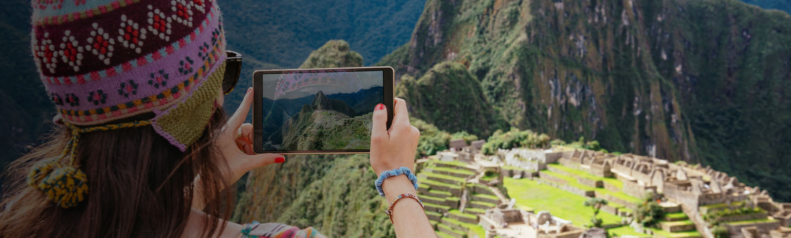 Peru, woman taking pictures of Machu Picchu citadel and Huayna Picchu.