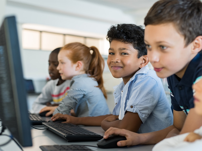 Four young children using computers