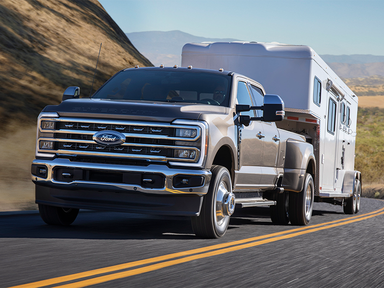 2023 Ford Super Duty truck on the road, pulling a trailer. 
