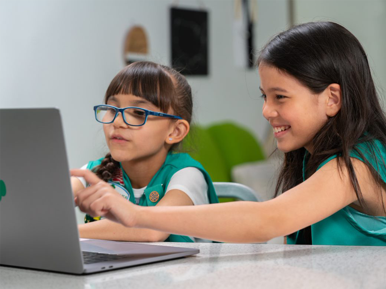 Girl Scouts doing homework on a connected laptop