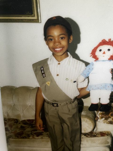 Jennifer Reed as a Girls Scout holding a doll