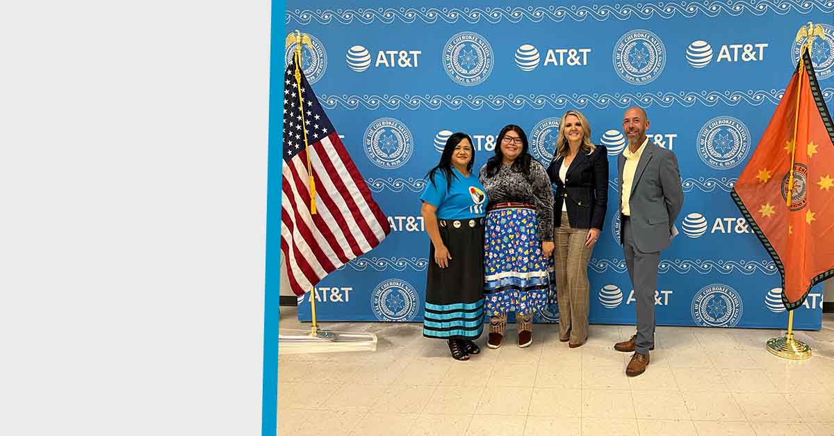 Left to right: AT&T employees Rachel Salinas, Angel Benally, Erin Scarborough and Joshua Davis pose for a group photo in front of a backdrop at the opening of the Cherokee Nation AT&T Connected Learning Center® in Catoosa, OK.