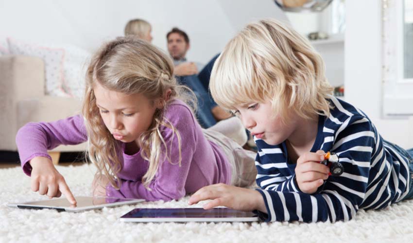 Two children playing on devices