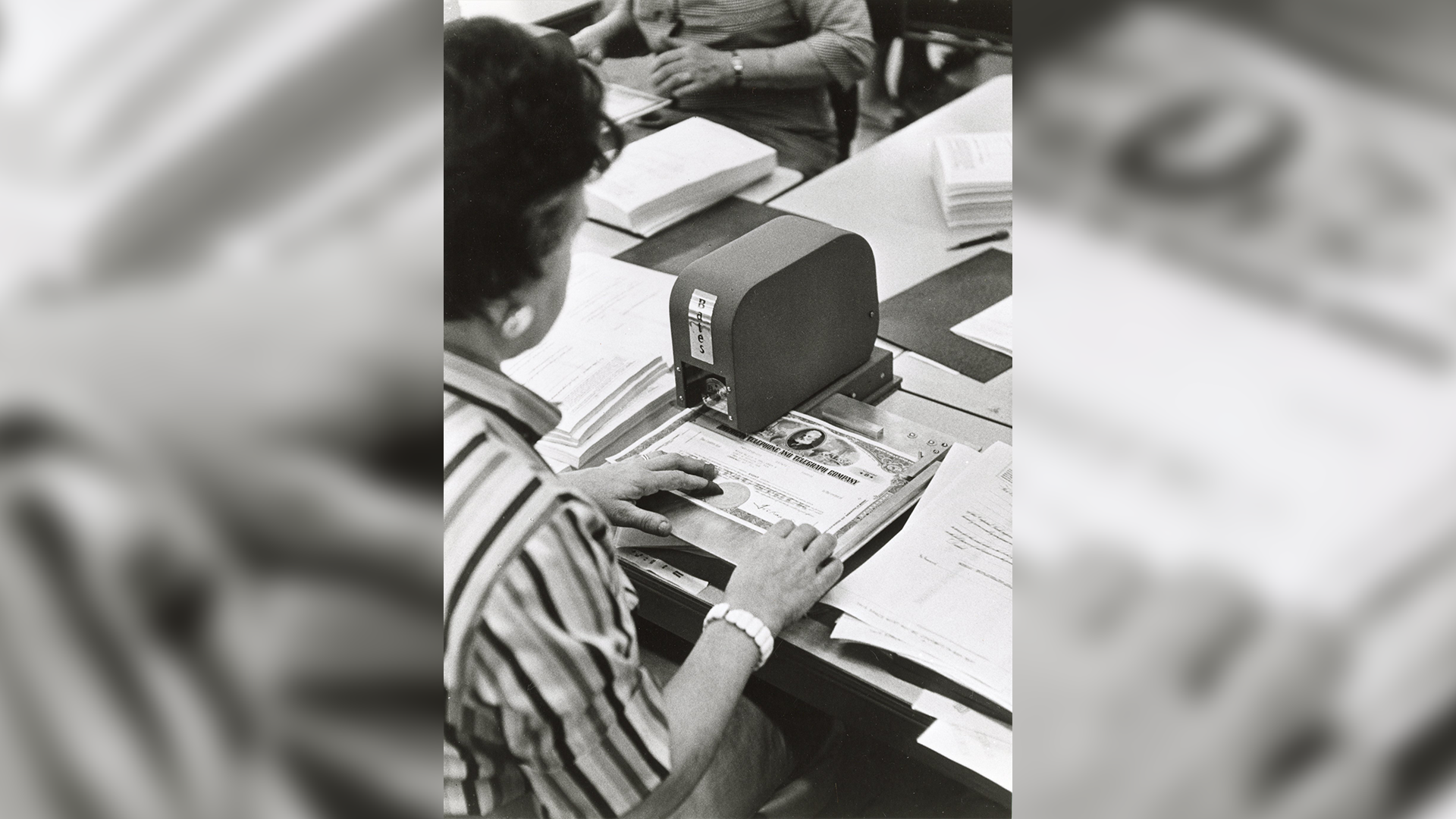 Image from 1959 of a stock certificate being processed